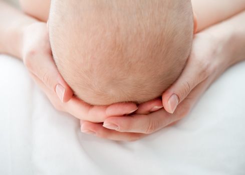 Mother holding her child's head, shallow DOF