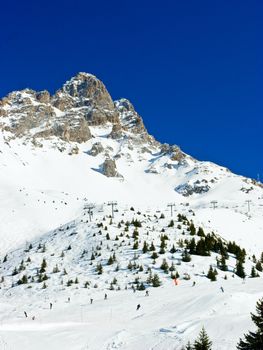 Skiers on a piste at Alpine ski resort