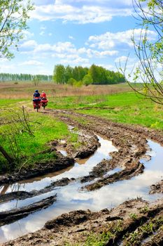 Traveling cyclists at muddy country road