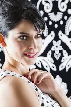 young woman in front of a black and white textured background, with 60's inspired style