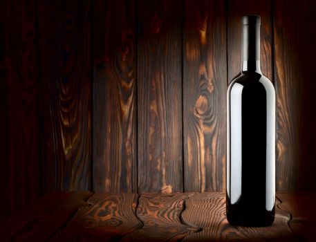 Bottle of red wine on a wooden background