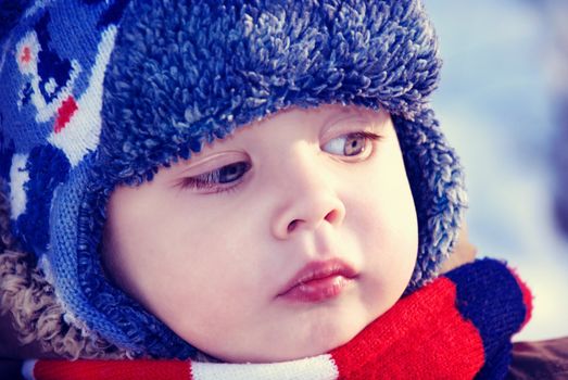 Closeup winter portrait of a child in winter hat.