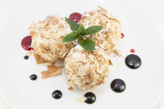 balls of ice cream decorated with mint on a white background in the restaurant
