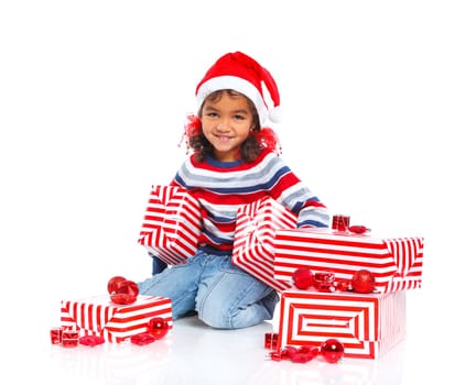 Smiling little mullato girl in Santa's hat with gift box, isolated on white