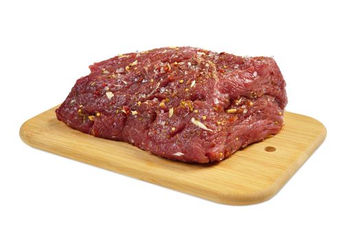 Beef on a wooden board with spices. Isolated on white