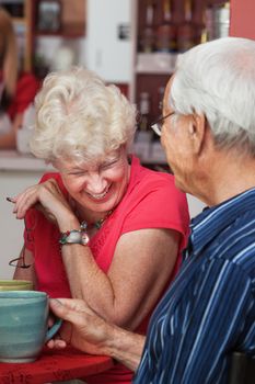 Older Caucasian woman laughing at table with man
