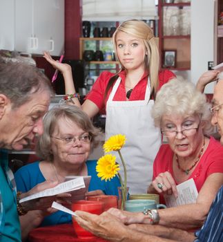 Frustrated waitress with customers trying to read the menu