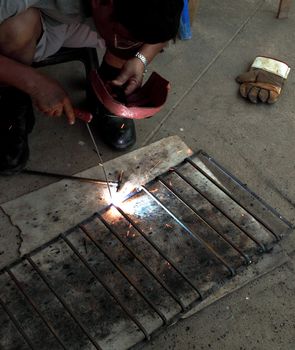 worker welding connecting square bar  without gloves