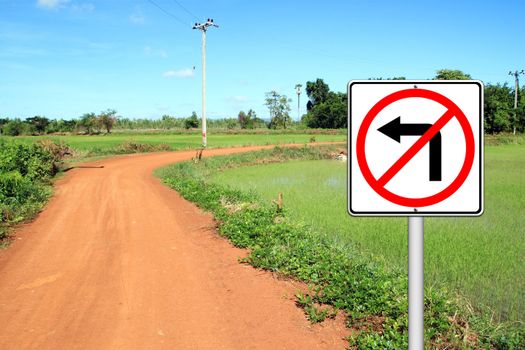 don't turn left sign with a left curved soil road