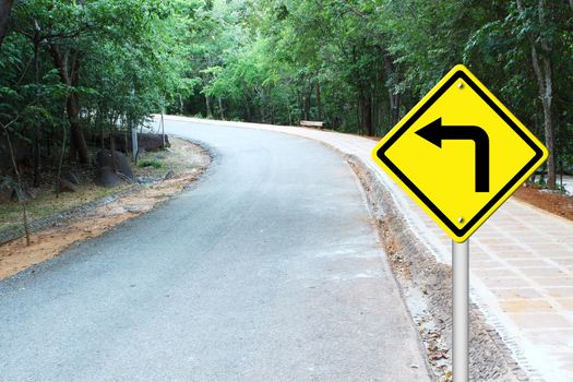 Turn left warning sign on a curve road