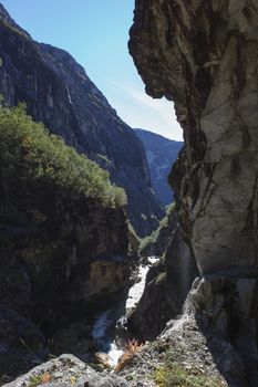 A waterfall in a beautiful autumn hills, with snow on the mountain peaks and beautiful colors of the trees