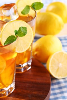 Close up of fresh and cold ice tea with sliced lemon and mint