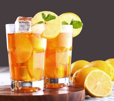 Close up of fresh and cold ice tea with sliced lemon and mint