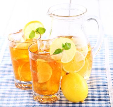 Close up of fresh and cold ice tea with sliced lemon and mint