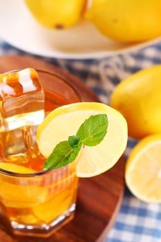 Close up of fresh and cold ice tea with sliced lemon and mint