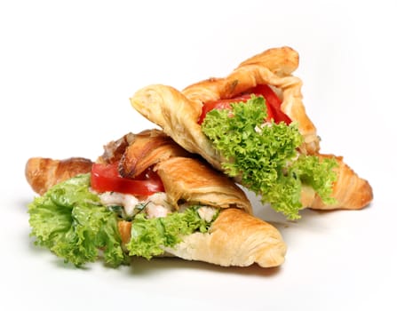 Close up of two tasty croissants with salad and tomato inside