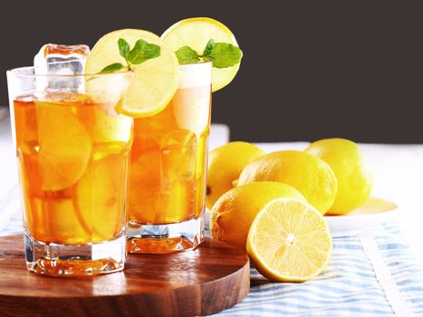 Close up of fresh and cold ice tea with sliced lemon and mint