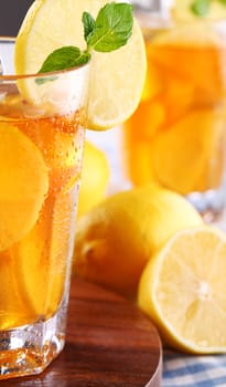 Close up of fresh and cold ice tea with sliced lemon and mint