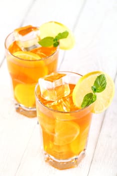 Fresh and cold ice tea with sliced lemon and mint