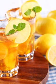 Close up of fresh and cold ice tea with sliced lemon and mint