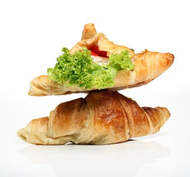 Close up of two tasty croissants with salad and tomato inside