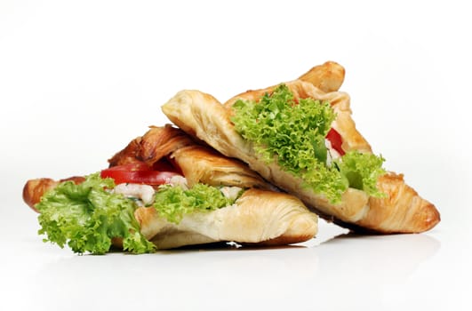 Close up of two tasty croissants with salad and tomato inside