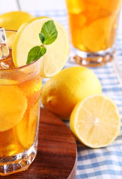 Close up of fresh and cold ice tea with sliced lemon and mint