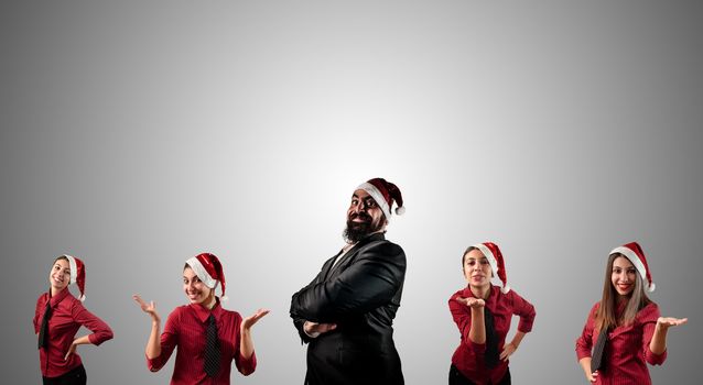 business santa claus and his christmas assistant girls on grey background