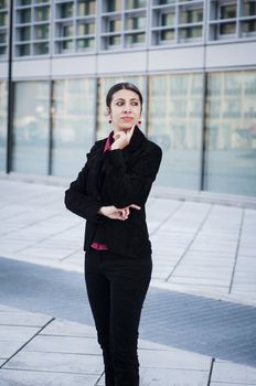 thinking business girl in front of modern building