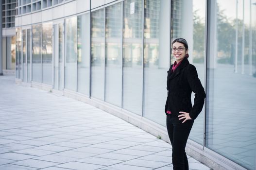 smiling business girl in front of modern building