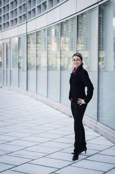 smiling business girl in front of modern building