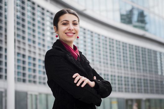 smiling business girl in front of a modern building