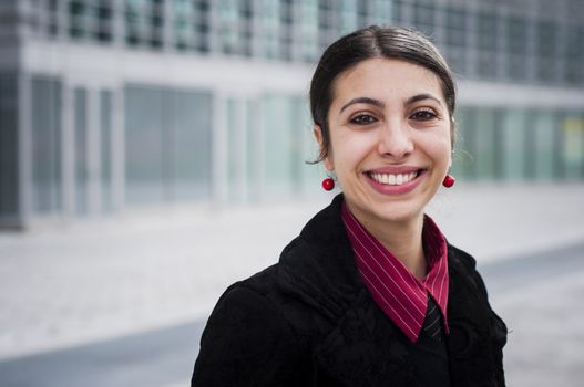 smiling business girl in front of a modern building