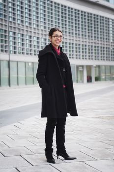 smiling business girl in front of a modern building