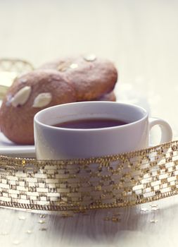 Cookies with nuts and a cup of tea on a background of Christmas gifts