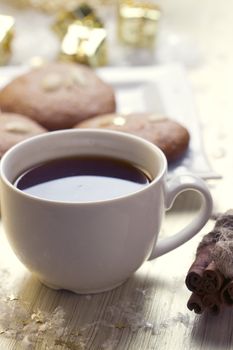 Cookies with nuts and a cup of tea on a background of Christmas gifts