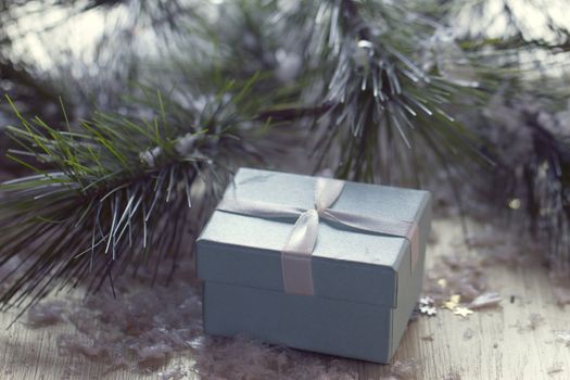 Gift box stands near the snow-covered trees