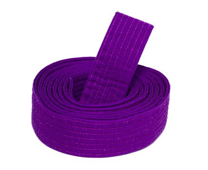 Coiled karate purple belt isolated on white background