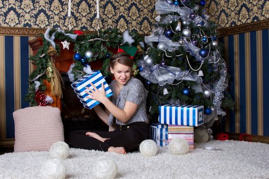 Beautiful girl with the present near the Christmas tree