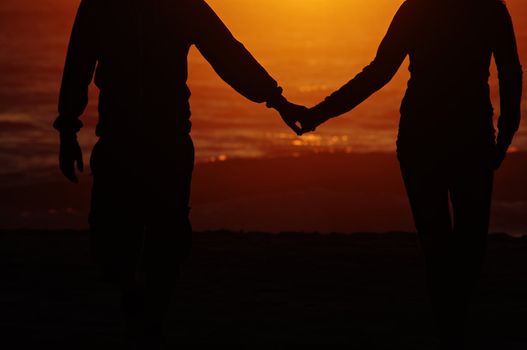 A couple on the beach with sunset background