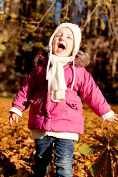 cute little child playing outdoor in autumn sunshine happy