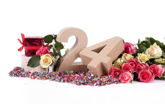 Number of age in a colorful studio setting with fresh roses on a bottom of confetti