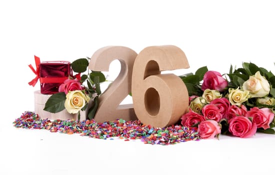 Number of age in a colorful studio setting with fresh roses on a bottom of confetti