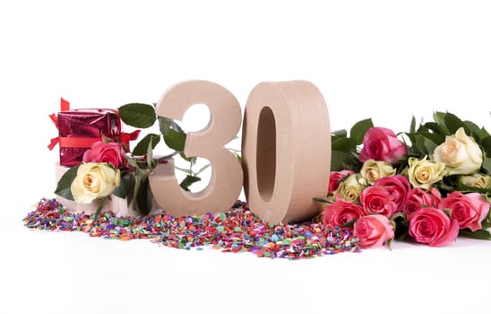 Number of age in a colorful studio setting with fresh roses on a bottom of confetti