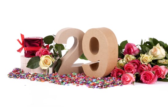 Number of age in a colorful studio setting with fresh roses on a bottom of confetti