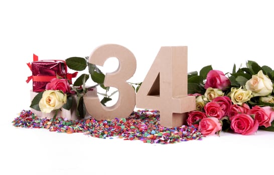 Number of age in a colorful studio setting with fresh roses on a bottom of confetti