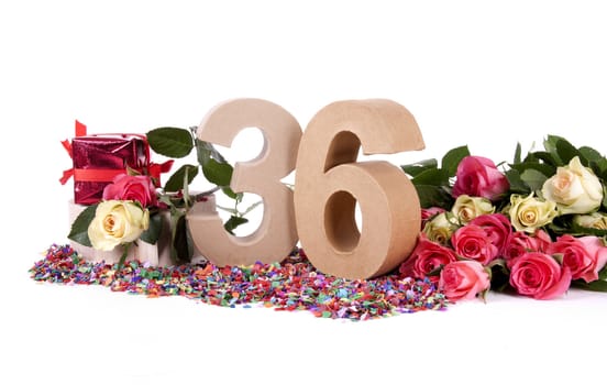 Number of age in a colorful studio setting with fresh roses on a bottom of confetti