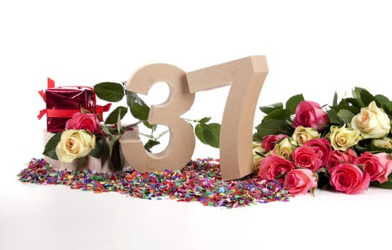 Number of age in a colorful studio setting with fresh roses on a bottom of confetti