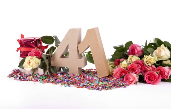 Number of age in a colorful studio setting with fresh roses on a bottom of confetti