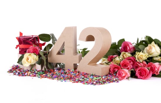 Number of age in a colorful studio setting with fresh roses on a bottom of confetti